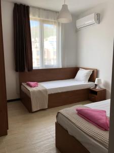a hotel room with two beds and a window at Aquamarine Apartments in Sveti Vlas