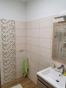 een badkamer met een wastafel en een douche bij Sunshine Resort Turquoise Apartman in Zamárdi