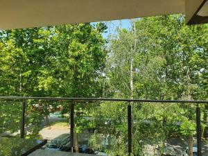a glass window of a house with trees at Sunshine Resort Turquoise Apartman in Zamárdi