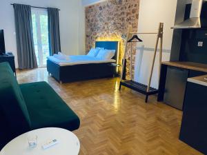 a bedroom with a bed and a couch and a table at Omega54 City Suites Athens Central Business District in Athens