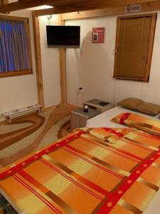 a bedroom with two beds and a flat screen tv at Apartment Sunny Place in Bihać +29 photos