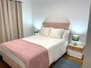 ein Schlafzimmer mit einem Bett mit einer rosa und weißen Decke in der Unterkunft Fabuloso apartamento en Los Cancajos in Los Cancajos
