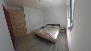 a small bedroom with a bed and a closet at Apartman G 60 in Meljine