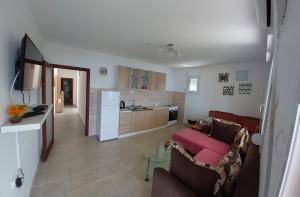 a living room with a couch and a kitchen at Apartman G 60 in Meljine