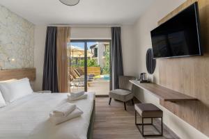 um quarto de hotel com uma cama e uma secretária com uma televisão em Sigma Luxury Rooms em Sivota