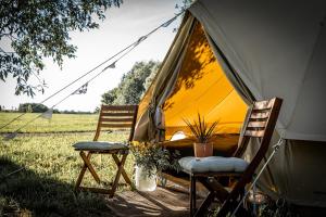 two chairs sitting in front of a tent at WPark Glamping in Põltsamaa