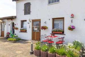 a white house with a table and chairs and flowers at Karlshagen_ Haus Boettcher in Ostseebad Karlshagen