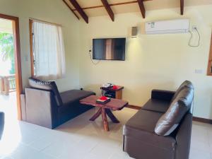 a living room with a leather couch and a table at Tavake Villa in Arutanga