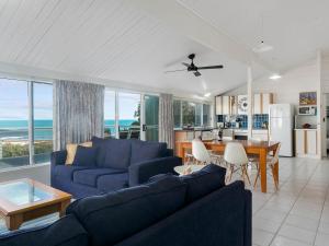 a living room with a blue couch and a table at Wave and See 53 Gold Coast Drive in Carrickalinga