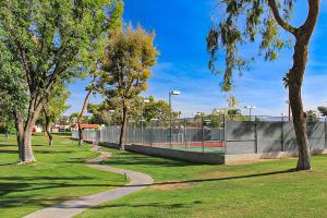 a tennis court in a park with trees at Red Roof Retreat in Rancho Mirage