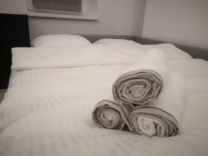 Una cama blanca con dos toallas enrolladas. en Apartamenty LENA 3, en Racibórz