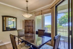a dining room with a table and chairs and a window at Kapalua Golf Villas 16V3 in Kahana