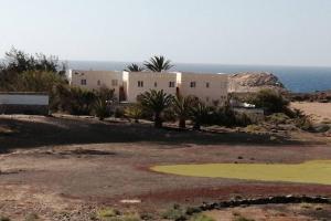 a house in the desert with the ocean in the background at Old King's beach house in Pájara