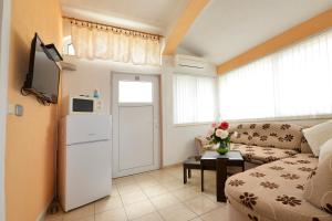 ein kleines Wohnzimmer mit einem Sofa und einem Tisch in der Unterkunft Apartments Ella in Poreč