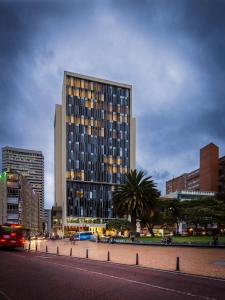 a tall building in a city with a street at Hotel bh Bicentenario in Bogotá