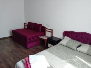 um quarto com uma cama e uma cadeira roxa em ЖК Варшавский квартал, Правды 41 em Kiev