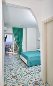 a bedroom with a bed with a turquoise bedspread at Malafemmena Guest House in Capri