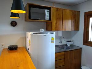 a kitchen with a white refrigerator and a sink at Residencial Franzen in Canela