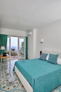 una camera da letto con un grande letto e un copriletto verde di Malafemmena Guest House a Capri