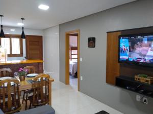 a kitchen and dining room with a television on a wall at Residencial Franzen in Canela