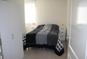 - une chambre avec un lit et une couverture noire et blanche dans l'établissement Casa 1-2-3, à Zandvoort