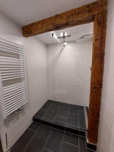 a shower room with a black tiled floor and a window at AnaCapri Gästehaus Le Havre in Ueckermünde