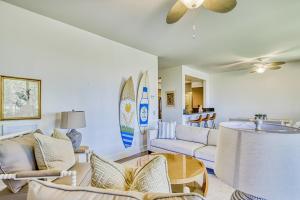 a living room with couches and surfboards on the wall at Shores at Waikoloa #214 in Waikoloa