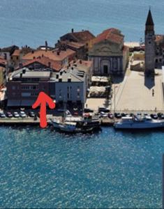 a red arrow is pointing to a city over the water at Lorena app in Umag