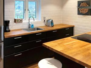 - une cuisine avec un évier et un comptoir en bois dans l'établissement 4 person holiday home in GARPHYTTAN, à Garphyttan