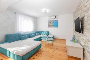 salon z niebieską kanapą w obiekcie Apartment Otasevic 1 w mieście Tivat