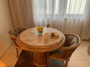 uma mesa de madeira com um prato de comida e flores em LANDMARK By Hotelaria Brasil em São Paulo