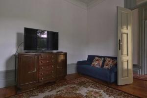 a living room with a tv and a blue couch at Casa de São Roque - Lamego in Cambres
