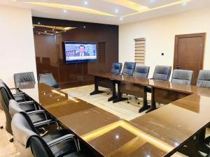 una sala de conferencias con una mesa grande y sillas en MayFair Hotel Maitama Abuja, en Abuja