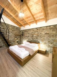 a bedroom with a bed and a stone wall at Amalia Hotel in Berat