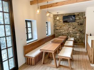 a restaurant with wooden tables and benches and windows at Amalia Hotel in Berat