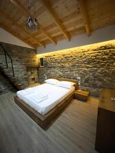 1 dormitorio con 1 cama en una pared de piedra en Amalia Hotel en Berat