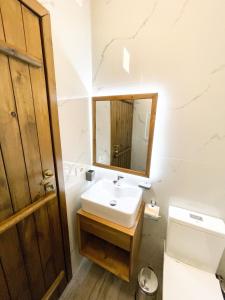 a bathroom with a sink and a toilet and a mirror at Amalia Hotel in Berat +30 photos