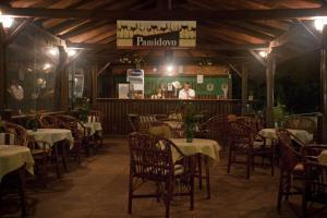 Ein Restaurant mit Tischen und Stühlen und ein Mann, der im Hintergrund steht in der Unterkunft Hotel Varshava in Goldstrand