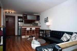 uma sala de estar com um sofá e uma mesa em Las Condes, Excelentes Apartamentos - Sofia Camilla Propiedades em Santiago