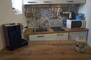 a kitchen with a sink and a microwave at Donna Rosalia in Amalfi +14 photos