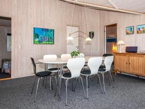 Knebelにある8 person holiday home in Knebelのダイニングルーム(白いテーブル、椅子付)