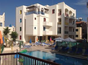a building with a swimming pool in front of a building at Sea N Lake View Hotel Apartments in Larnaka