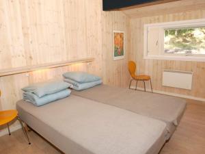 a bedroom with two beds and a chair and a window at 8 person holiday home in Nex in Vester Sømarken