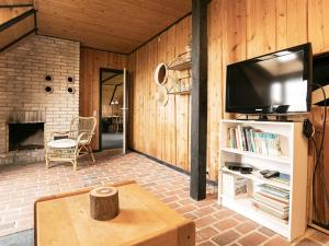 ブラーバンドにあるThree-Bedroom Holiday home in Blåvand 2のリビングルーム(テレビ、暖炉付)