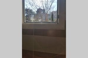 a window in a bathroom with a woman looking out at Calanques de Sormiou in Marseille
