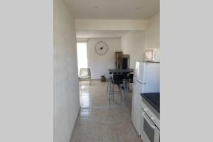 a kitchen with a refrigerator and a table with chairs at Calanques de Sormiou in Marseille