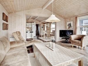 a living room with a couch and a table at 6 person holiday home in Hj rring in Hjørring