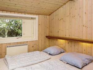 two beds in a room with a window at 12 person holiday home in Aakirkeby in Vester Sømarken