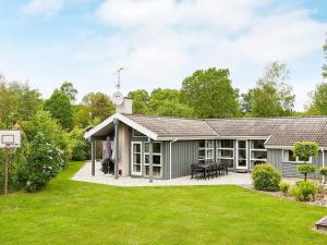 an exterior view of a house with a lawn at Four-Bedroom Holiday home in Glesborg 2 in Glesborg