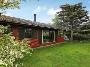 a small red house with a grass yard at 6 person holiday home in Vinderup in Vinderup